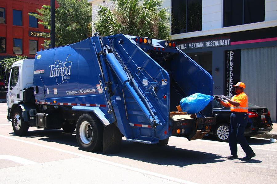 Solid Waste Worker loading bag onto collection vehicle